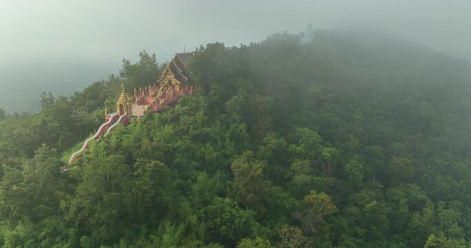 Aerial View at Morning Wat Phra That Doi Phra Chan. and Daibutsu Buddha on the mountain at Lampang Province Thailand 4k video from Drone.
