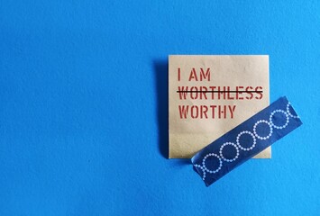 Note stick on copy space blue background, concept of self talk affirmation to overcome low self...