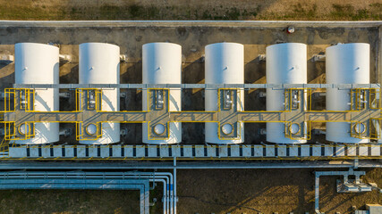Aerial view white oil storage fuel tanks at depot station, White Industrial tanks for gasoline petrol and oil fuel with pipeline, Oil and gas industrial, Oil refinery plant industry.