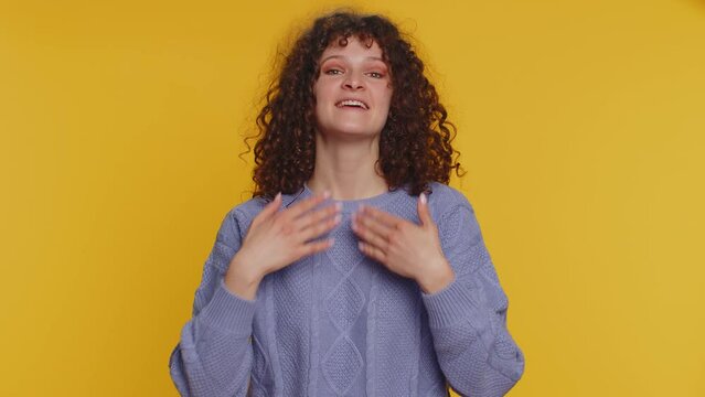 Free gifts and presents for you. Curly haired woman opening hands, glad to see, excitement, preparing surprise, sharing love emotions, congratulating. Young girl isolated on yellow studio background