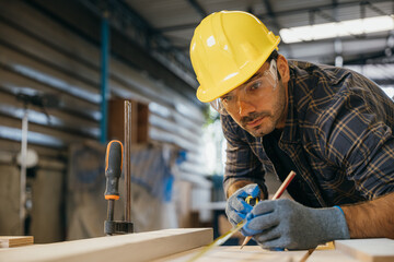 Carpenter man wear gloves during working using tape measure and pencil to make marks piece of wood board for cut on table saw at workshop or woodshop industry, woodwork, Happy Carpenter's Day