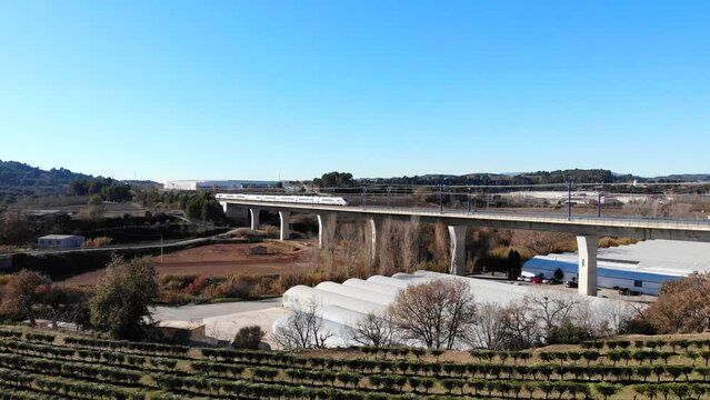 Aerial: high-speed train crossing a viaduct in Spain, between Barcelona and Madrid. Catalonia.