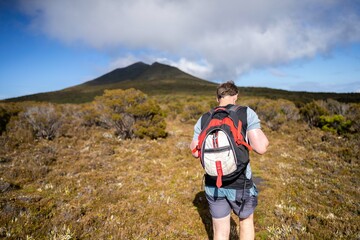 man hiking up a mountain with a backpack