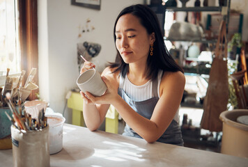 Pottery, art and sculpture with a japanese woman in a studio for design or a creative hobby as an...