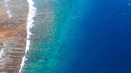 Sea waves reaching tropical beach on Nusa Lembongan, aerial landscape of island near Bali, Indonesia. Summer travel concept.