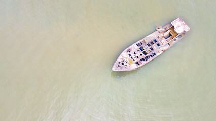 Aerial view over unknown wreck ship in the sea near Saphan Hin in Phuket, Thailand.