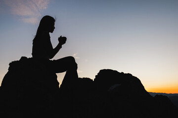 Silhouette of christian woman hand praying, Woman praying in the morning on the sunrise background. spirituality and religion, woman praying to god. Christianity concept.
