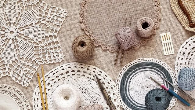 Needlework and crochet concept. Hand knitted lace doilies and crochet accessories on canvas background. Flat lay, close up, top view, mock up
