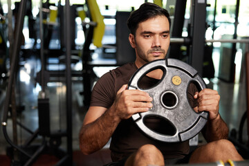 young athletic man exercise with weight lifting rubber plates in the gym