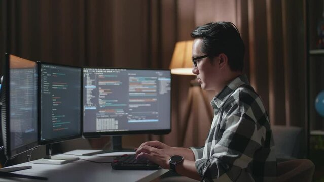 Asian Male Programmer Creating Innovative Software Engineer Developing App, Program, Video Game On Desktop Computer At Home. Terminal With Coding Language 
