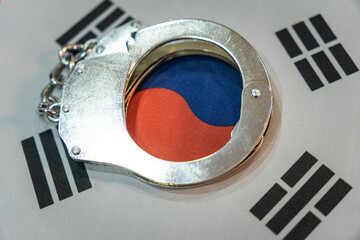 south korea flag and police handcuffs. The concept of observance of the law in the country and...