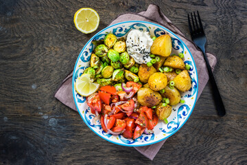 Brussel sprouts and tomato salad bowl, healthy and balanced food with baked potatoes