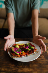 Сlose-up hands holding a plate of food, top view.