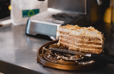 half eaten cake on the kitchen table, dirty knife. coffee machine. dessert with coffee in an authentic setting