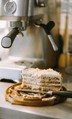 half eaten cake on the kitchen table, dirty knife. coffee machine. dessert with coffee in an authentic setting