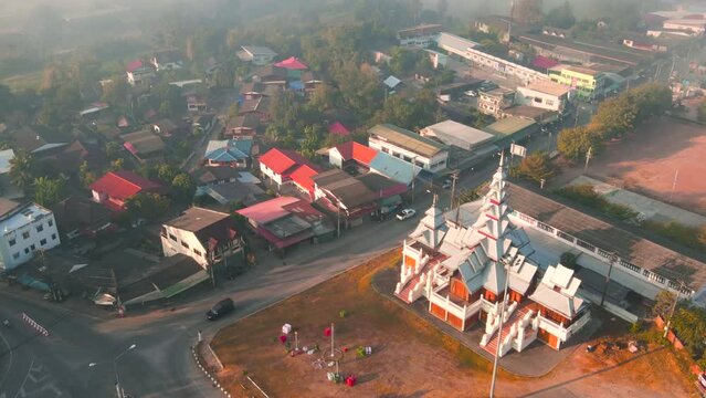 Motion time lapse in the morning foggy with Shan temple-style museum or exhibition hall of Mae Sariang district Mae Hong Son province Thailand. Aerial view dolly in with tilt down and panning camera.