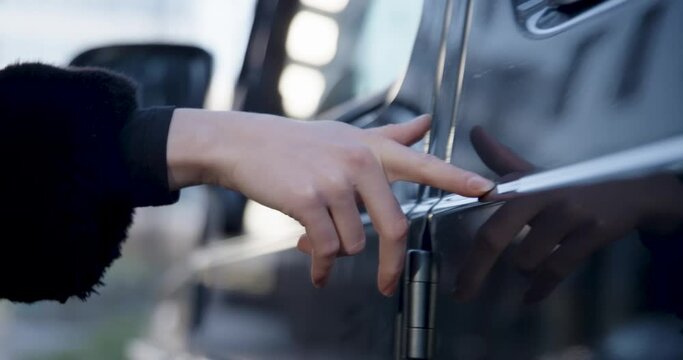 Woman touches car with fingers.