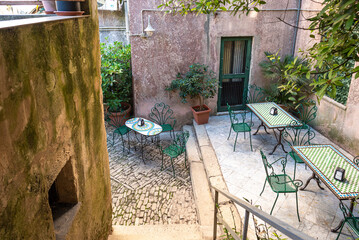 Outdoor seating area in the courtyard of a famous pastry shop in the mountain village of Erice in...