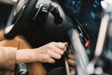Close up of a hand changing radio station in car.