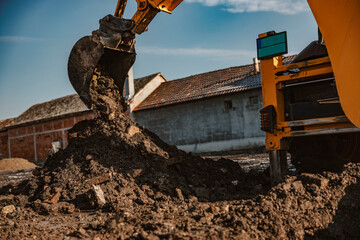 Cropped picture of a earthmover digging trench on construction site.