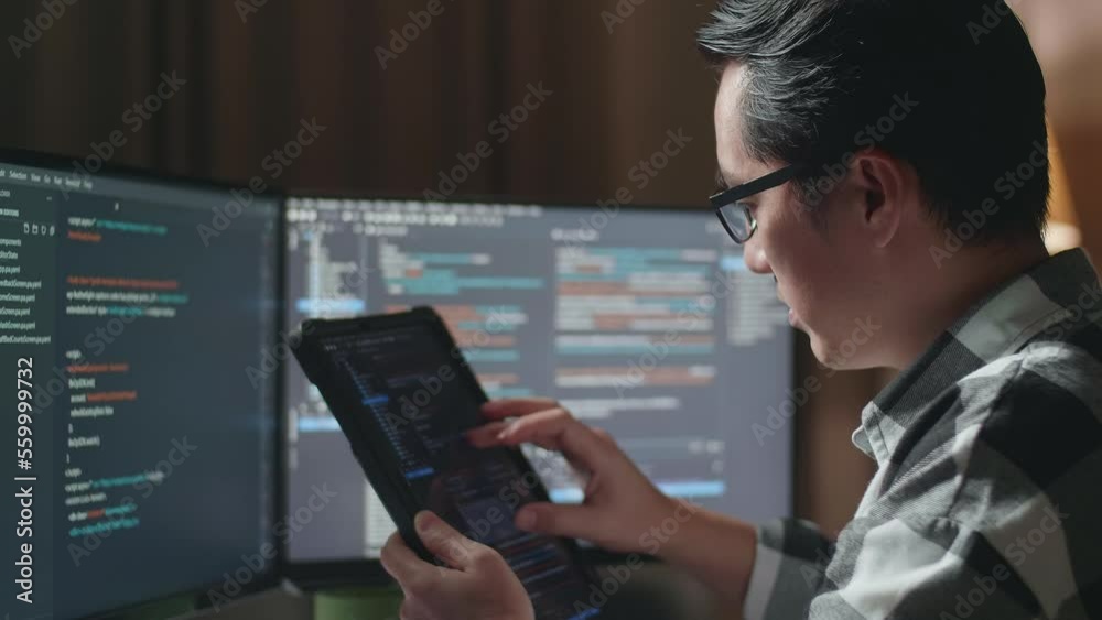 Wall mural close up of asian male programmer looking at database on tablet while creating software engineer dev