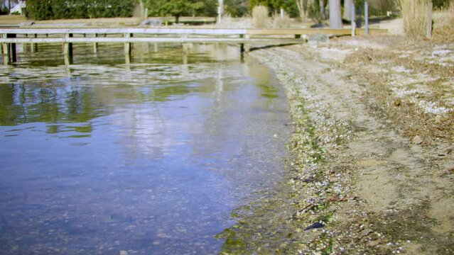 Rustling water along a beach head with a deck.