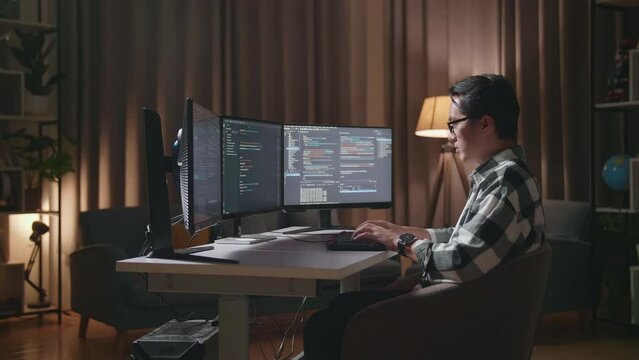 Asian Male Programmer Creating Innovative Software Engineer Developing App, Program, Video Game On Desktop Computer At Home. Terminal With Coding Language 
