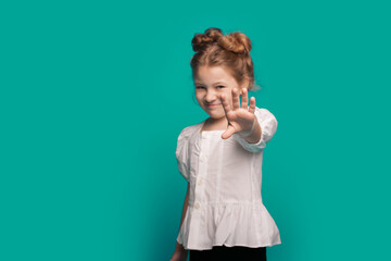 Smiling little girl stretching out her hand and asking for something isolated over blue background. Please give me a thing.