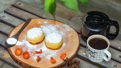 Tasty home made icing sugar donuts served with a glass of coffee