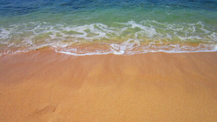Obraz premium Golden sand beach and soft waves of the ocean. Beautiful background of summer day.
