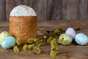 Painted Easter eggs, willow branch and cake on dark wooden table