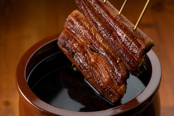鰻の蒲焼きを秘伝のタレに漬ける