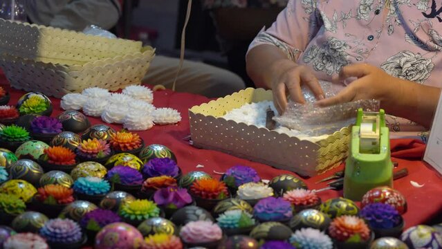 Asian Businesswoman Packing Carved Thai Soap Flowers With Bubble Wrap For Delivery In Thailand. closeup