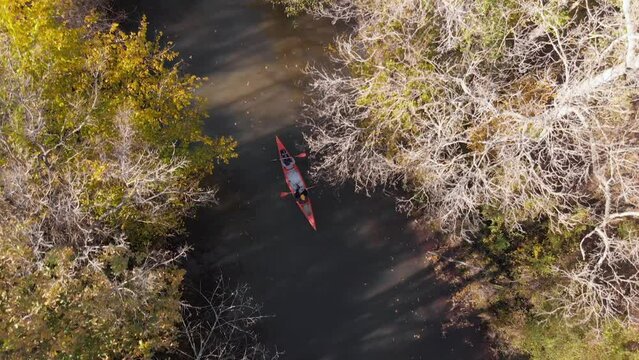 man and woman with canoe advance on the river in autumn, drone follows from the air Turkey iğneada