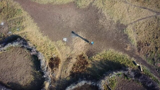 Overhead drone shot of a Karamojong woman carrying things with her head, Uganda. High quality 4k footage.