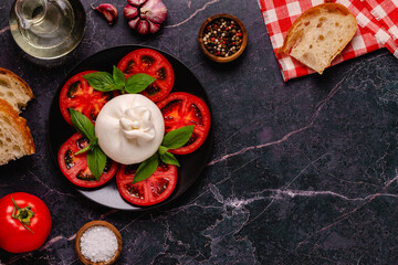 Caprese salad with tomatoes, burrata cheese and basil.