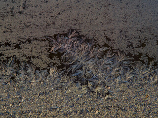 Frosty pattern of natural ice crystals on a dark background. Macro close-up.