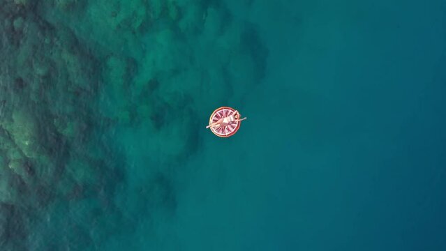 in summer the girl lies on the colorful seabed, the drone shoots upwards Turkey