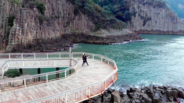 boy and girl dancing next to lava pillars, drone shot backwards from the air turkey bartın