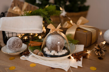Chocolate bomb in a container decorated with a satin ribbon, in the Christmas interior