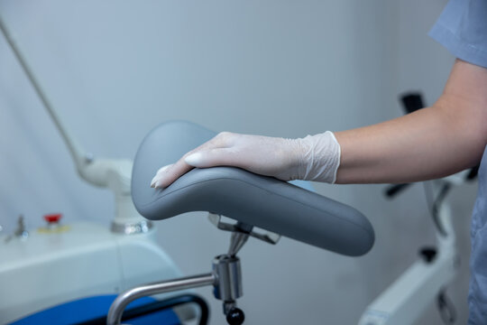 Close up of deoctors hand on a gynecological examination chair