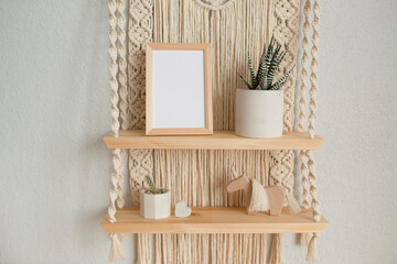 Mockup wooden frame on decorative shelves macrame in the interior