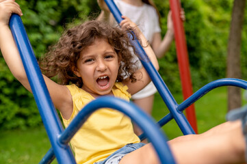 Cute girl on thw swing looking excited