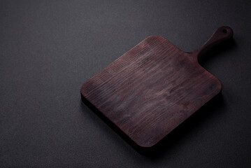 .Empty brown wooden cutting board on dark concrete background