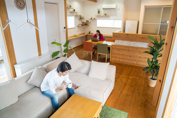 スマホを見る男性とパソコンを見る女性