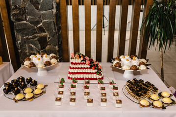 Candy bar with desserts for celebrating birthday, baptism, wedding. Table with cake, sweets, candies, dessert.