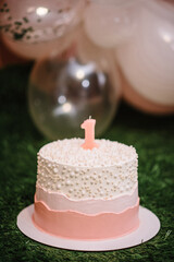 Birthday cake for 1 year. The cake is decorated with candle and decor for the girl. Delicious...