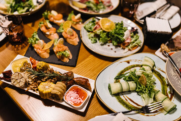 Served dinner table in restaurant interior. Wedding festive dinner. Delicious dishes on the table in the restaurant. Serving table, birthday setting. Top view.