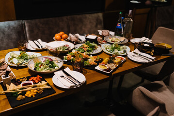 Served dinner table in restaurant interior. Wedding festive dinner. Delicious dishes on the table in the restaurant. Serving table, birthday setting.
