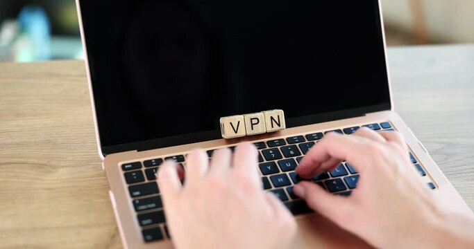 Wooden cubes with inscription vpn and hands on keyboard